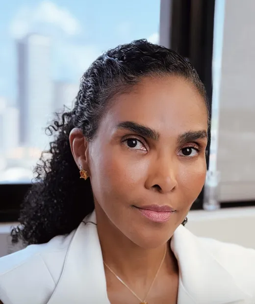 Dra. Rosana Frempong no consultório, com a cidade ao fundo