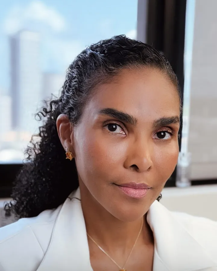 Dra. Rosana Frempong no consultório, com a cidade ao fundo pela janela