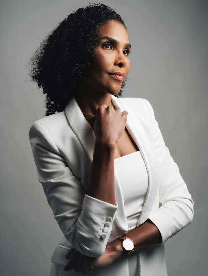 Retrato da Dra. Rosana Frempong, de blazer branco, com a mão apoiada no queixo