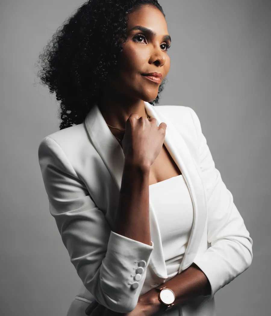 Retrato da Dra. Rosana Frempong, de blazer branco, com a mão apoiada no queixo
