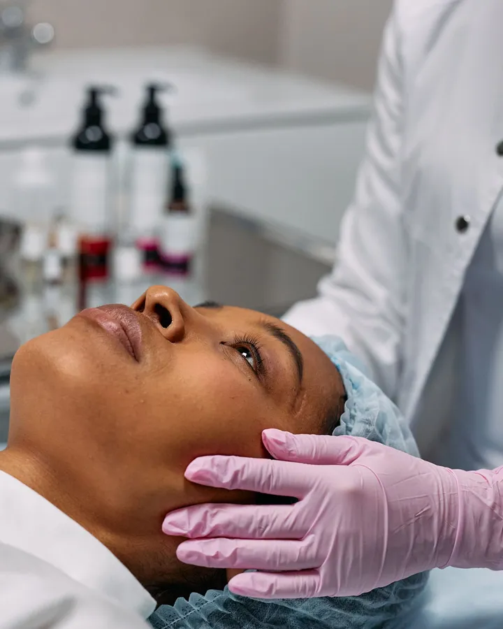 Profissional avaliando o contorno do rosto de uma paciente negra