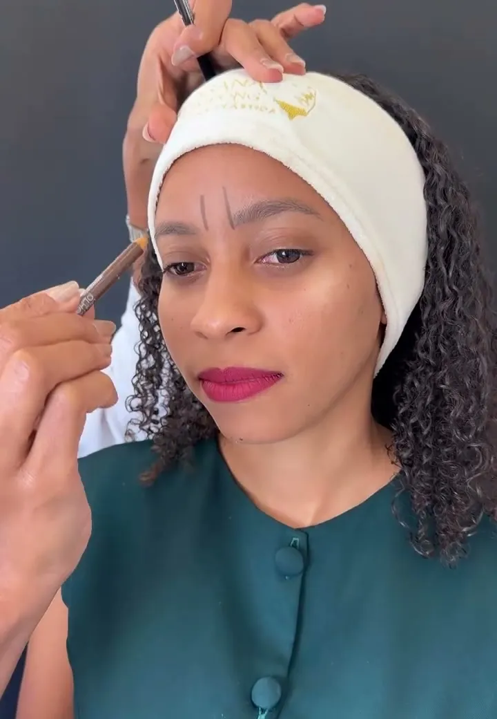 Dra. Rosana Frempong marcando os pontos de aplicação na região entre as sobrancelhas de uma modelo, em vídeo educativo