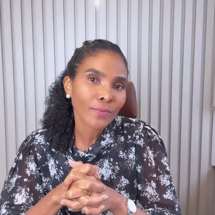 Dra. Rosana Frempong sorrindo, com as mãos entrelaçadas sobre a mesa