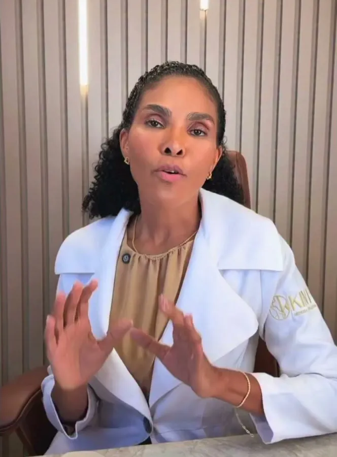 Dra. Rosana Frempong explicando, à mesa, com implantes sobre a mesa